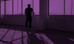 A solitary figure standing in a purple-hued room, with a vast cityscape visible through the left-side window. The black-clad person holds a white object, casting a shadow on the floor, evoking a sense of introspection.